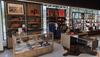 Tecovas Kingston Pike store interior. Displaying boots, hats, and leather goods on shelves and in glass cases, with natural light from large windows and neatly organized merchandise.